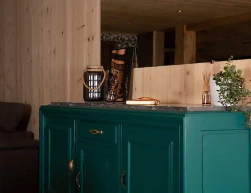 Buffet vert foncé avec objets décoratifs posés dessus, dans une pièce en bois naturel.Les gîtes du haut bois 2 Le Haut Bois, 25650 Ville-du-Pont, France