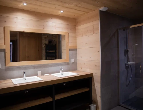 Salle de bain en bois avec double vasque et grand miroir mural, ambiance chaleureuse.Les gîtes du haut bois 2 Le Haut Bois, 25650 Ville-du-Pont, France