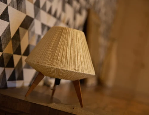 Décoration intérieure avec mur géométrique noir et beige, miroir et objets en rotin sur une commode.Les gîtes du haut bois 2 Le Haut Bois, 25650 Ville-du-Pont, France