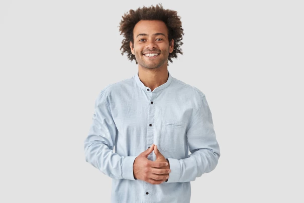 Homme souriant en chemise claire, les mains jointes, sur fond gris clair.Les gîtes du haut bois 2 Le Haut Bois, 25650 Ville-du-Pont, France