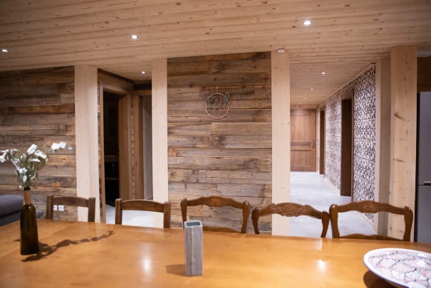 Chambre avec lit double en bois clair et mur tapissé de motifs floraux sombres.Les gîtes du haut bois 2 Le Haut Bois, 25650 Ville-du-Pont, France