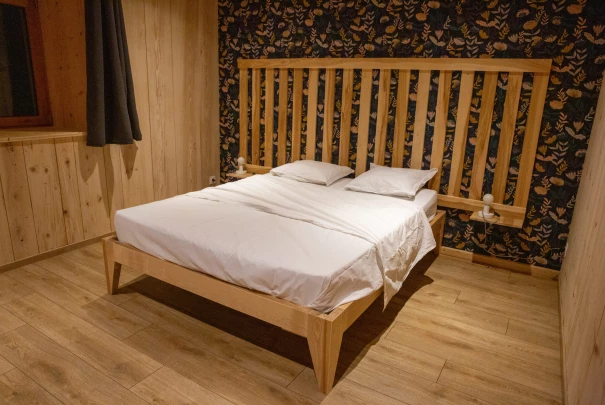 Salle à manger avec table en bois massif, chaises traditionnelles et mur en bois vieilli donnant sur un couloir.Les gîtes du haut bois 2 Le Haut Bois, 25650 Ville-du-Pont, France