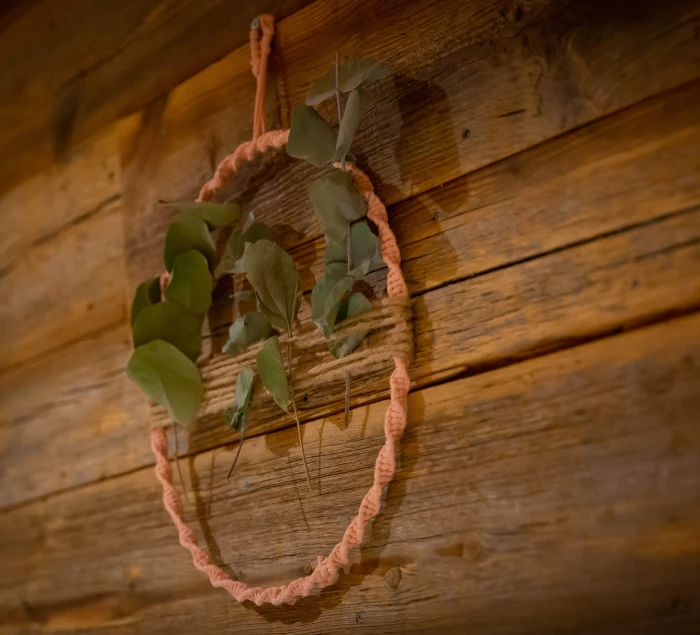 Cercle en corde décoratif avec feuillage accroché sur un mur en bois rustique.Les gîtes du haut bois 2 Le Haut Bois, 25650 Ville-du-Pont, France